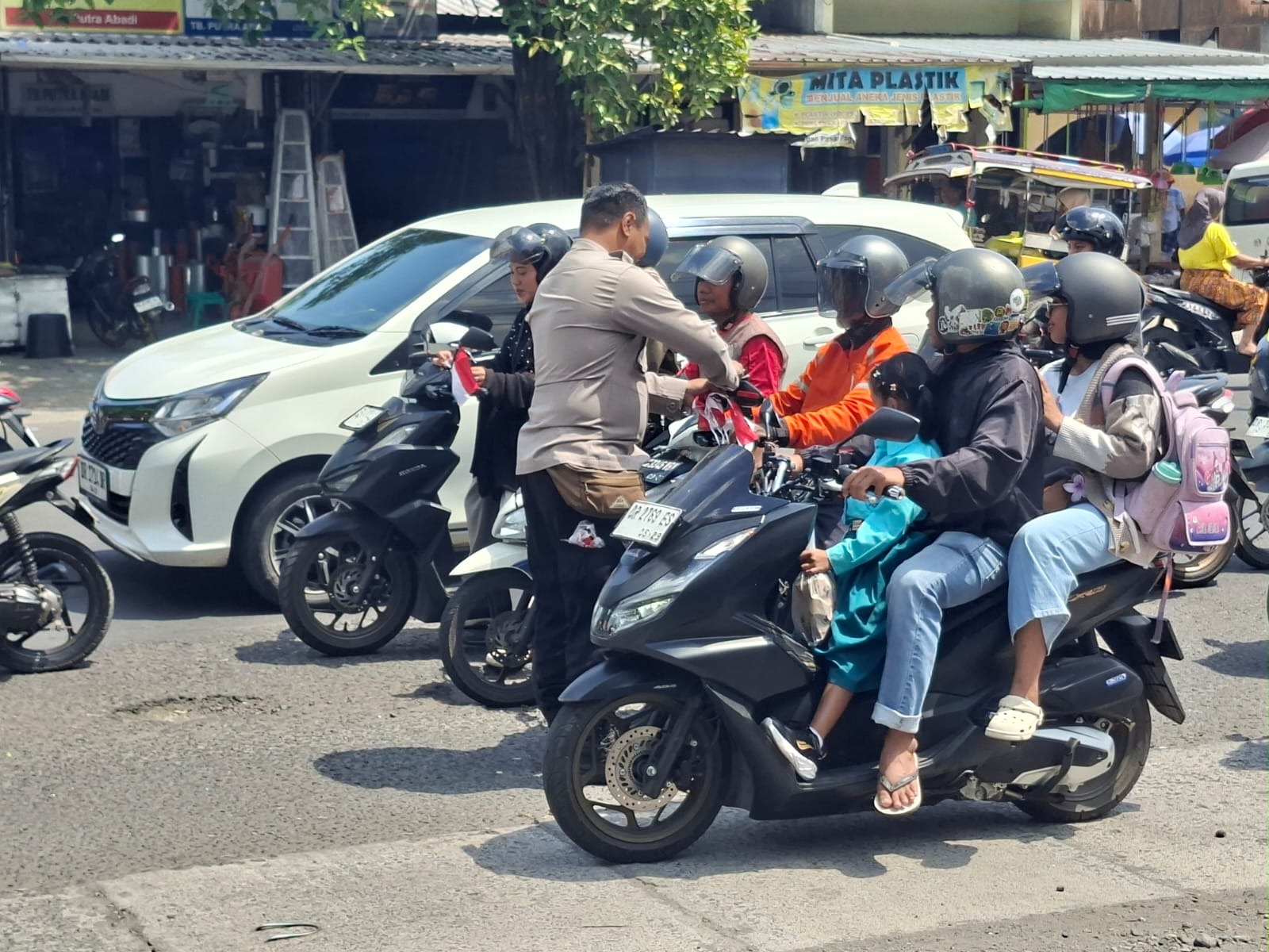 Sambut HUT RI ke-81 RI, Polsek Mataram Bagikan Bendera Merah Putih kepada Warga